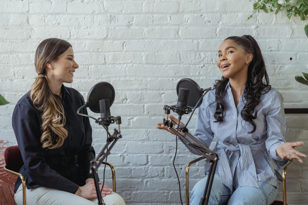 兩位女性 Podcast 主持人正在錄音室進行節目訪談