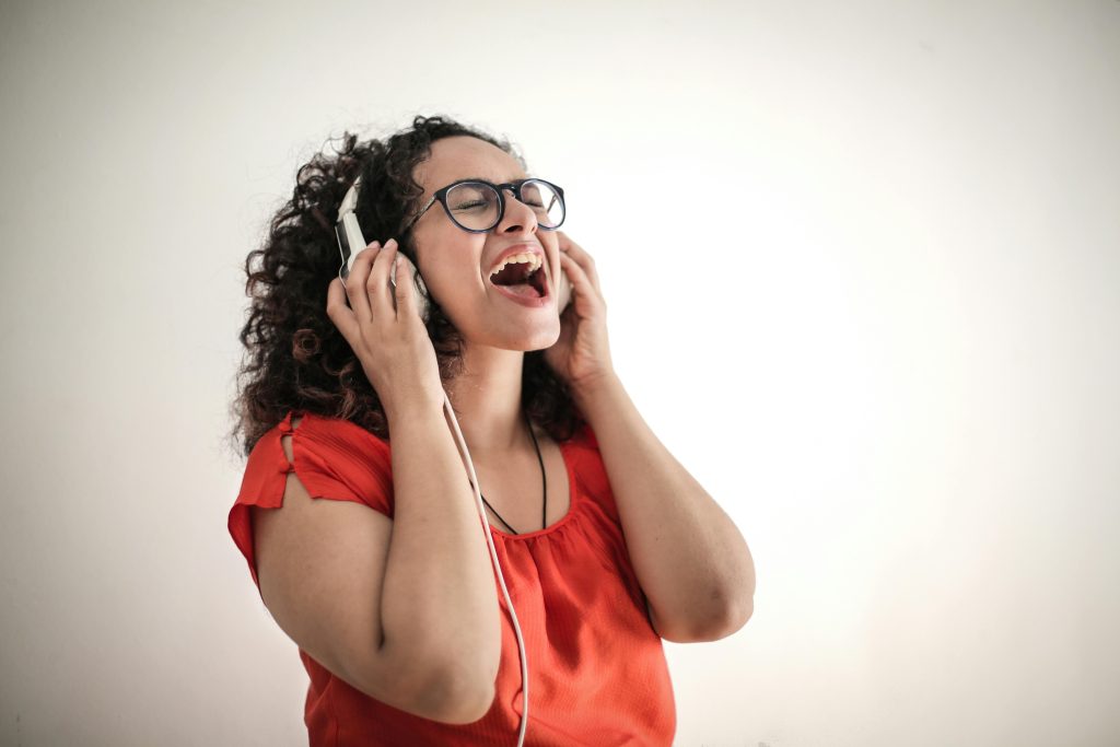 開心聆聽音樂並專注練習樂理的女性