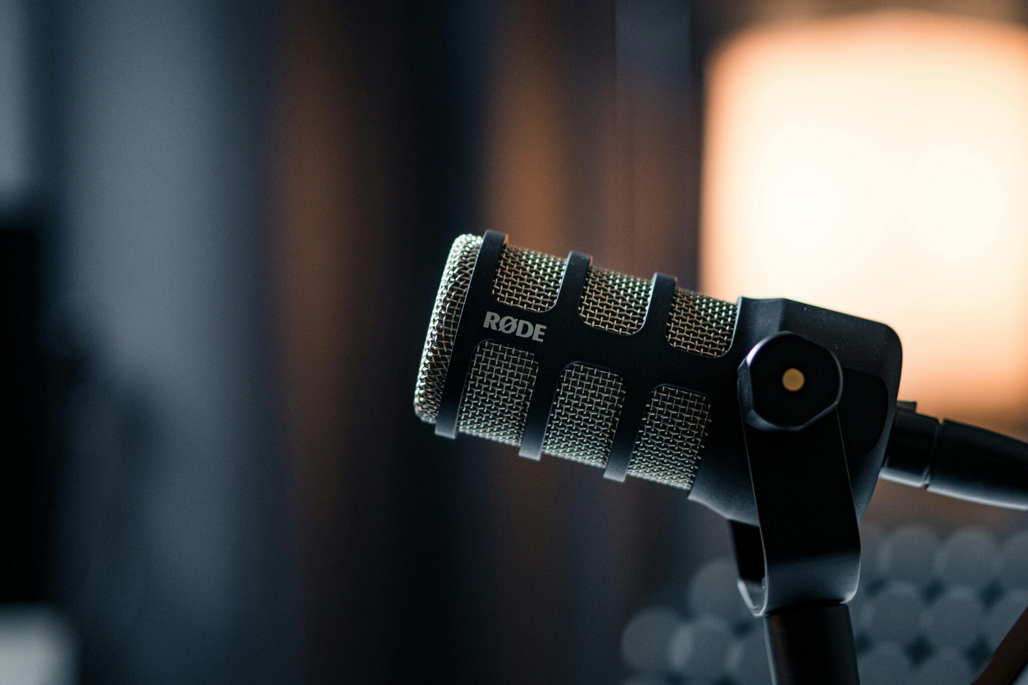 黑色 RØDE 動圈式麥克風特寫，象徵 Podcast 節目製作專業錄音設備