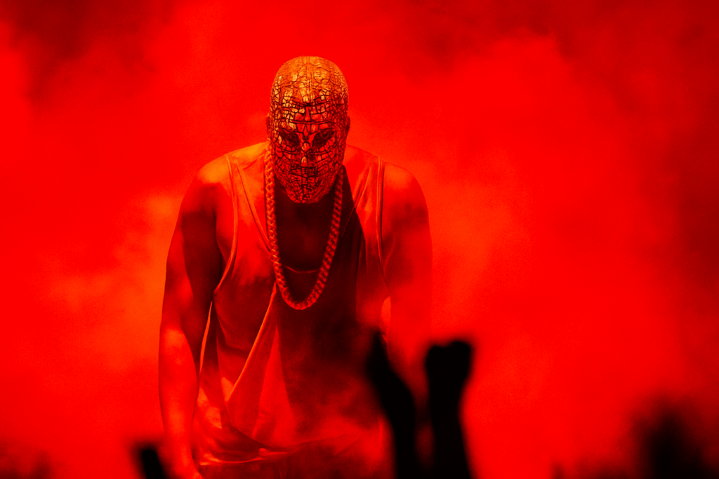 Kanye West 嘻哈演唱會舞台表演，紅色燈光與面罩造型