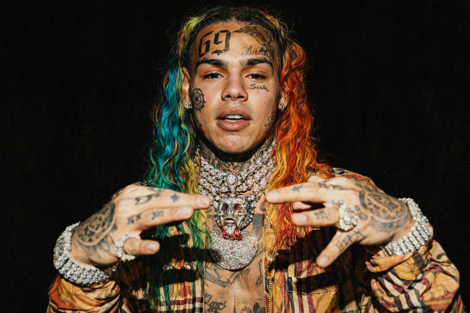 6ix9ine 近距離肖像,彩色長髮、臉部刺青與鑽石項鍊,展現極具爭議性的嘻哈形象