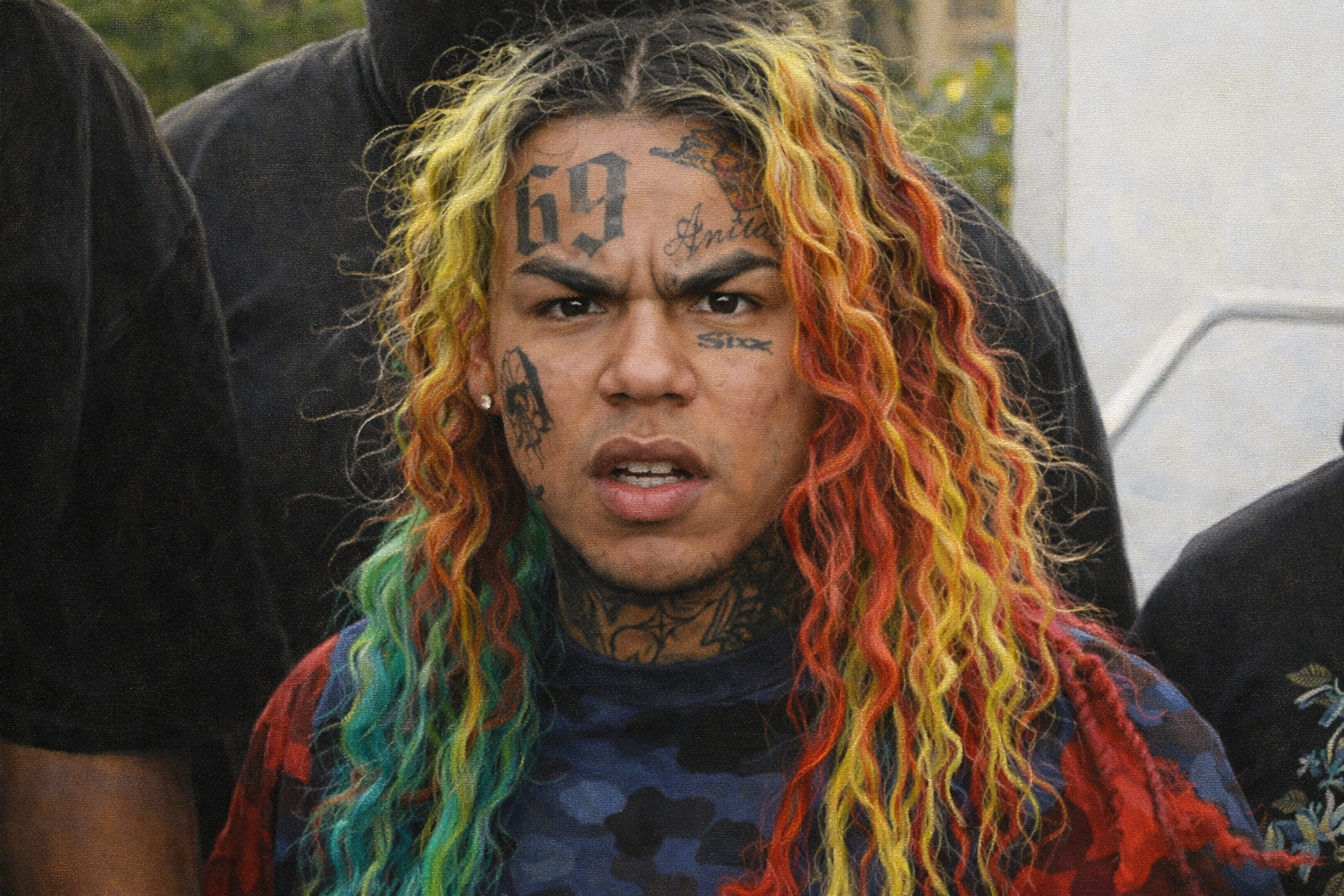 6ix9ine 正面近距離肖像,彩色長髮與額頭「69」刺青清晰可見,展現強烈對抗性的表情