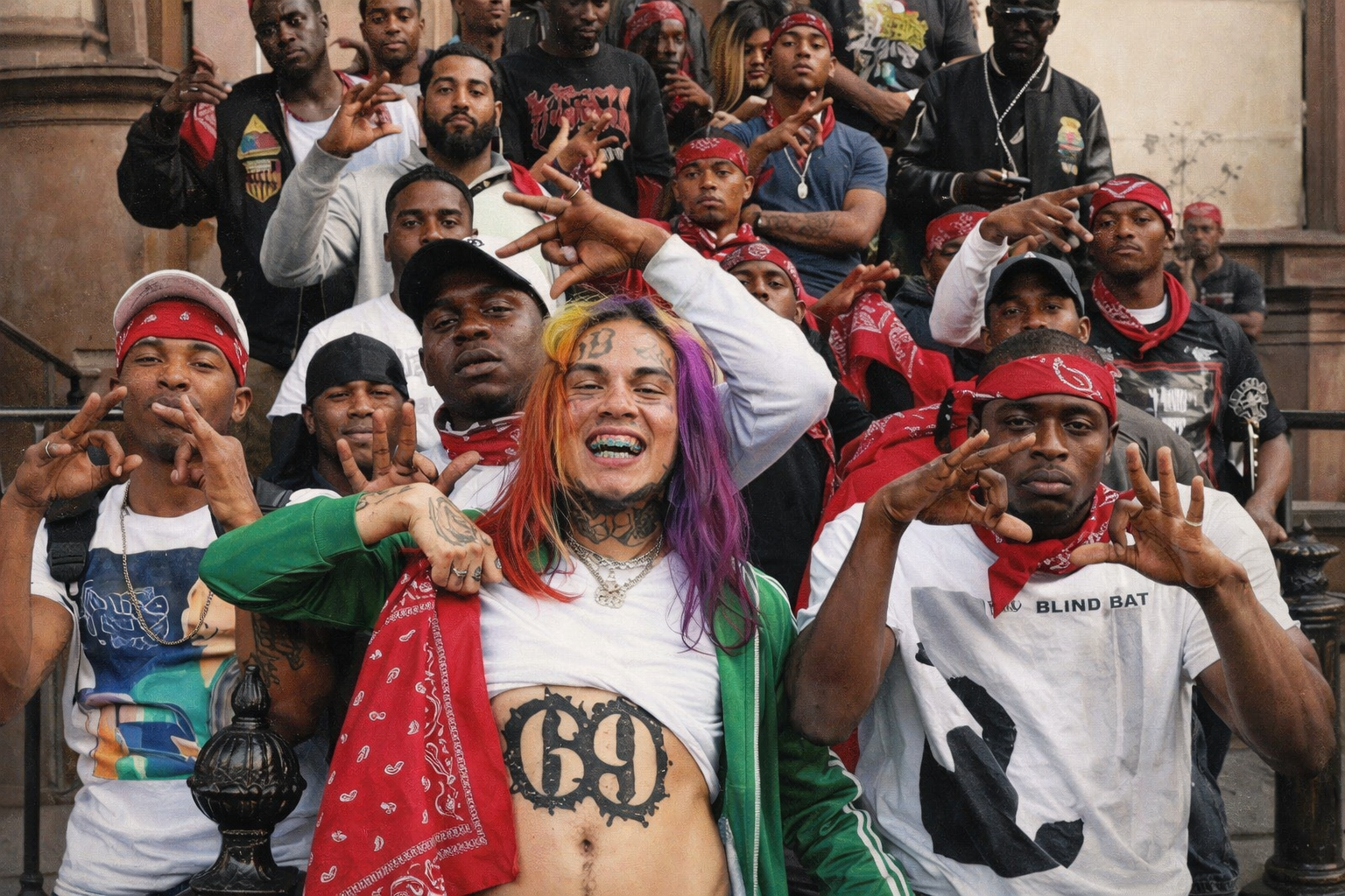 6ix9ine 與多名成員合影,額頭與腹部「69」刺青清晰可見,身穿綠色外套與紅色頭巾,展現街頭幫派風格形象