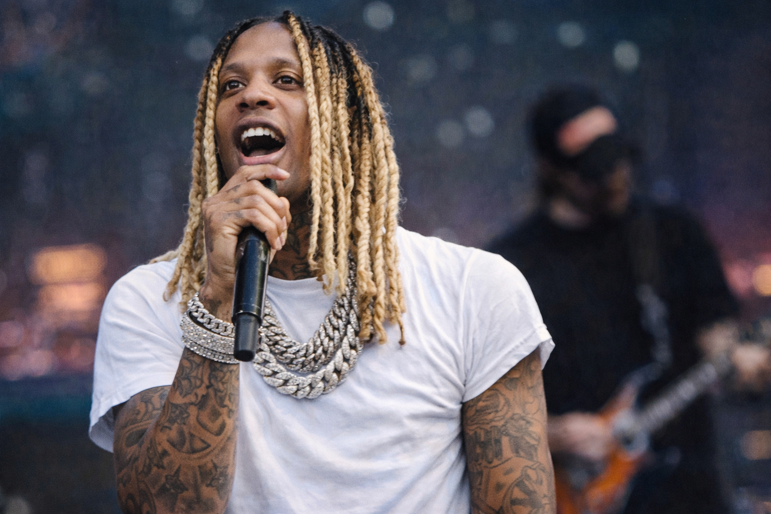 Lil Durk 手持麥克風在演唱會舞台上演出，展現饒舌歌手的現場感染力