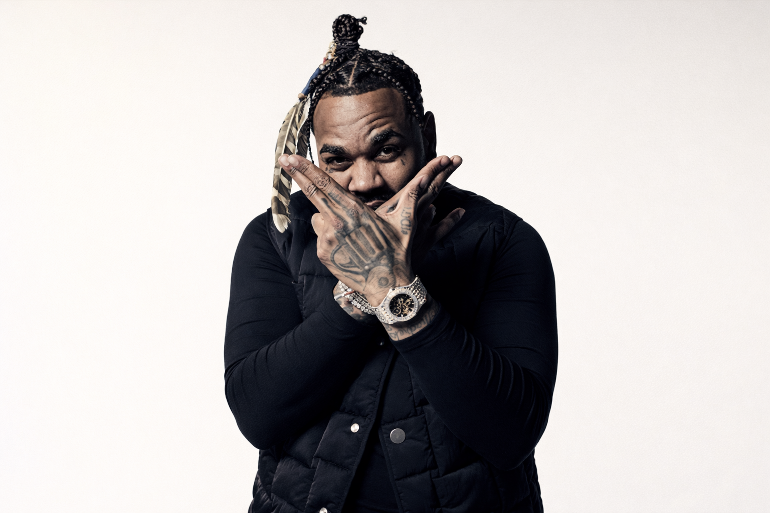 Kevin Gates 肖像照，雙手交叉遮住臉部，展現饒舌歌手的內斂力量與刺青細節