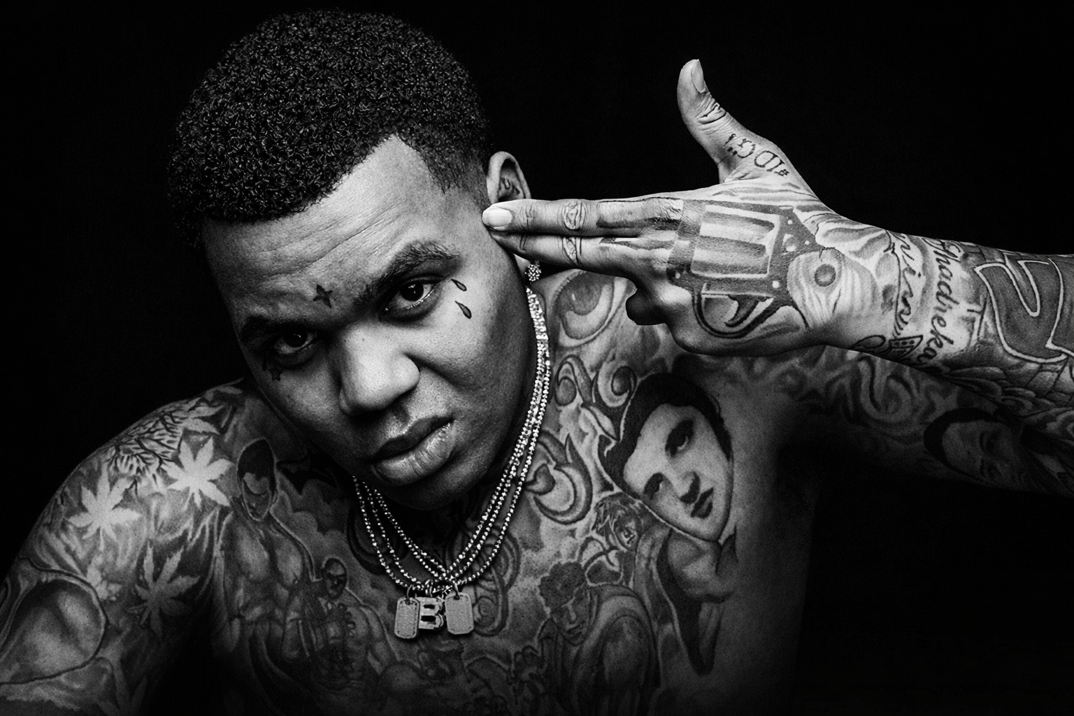 Kevin Gates 黑白人體藝術肖像，手勢模擬手槍指向頭部，呈現饒舌歌手的內在衝突與真實掙扎