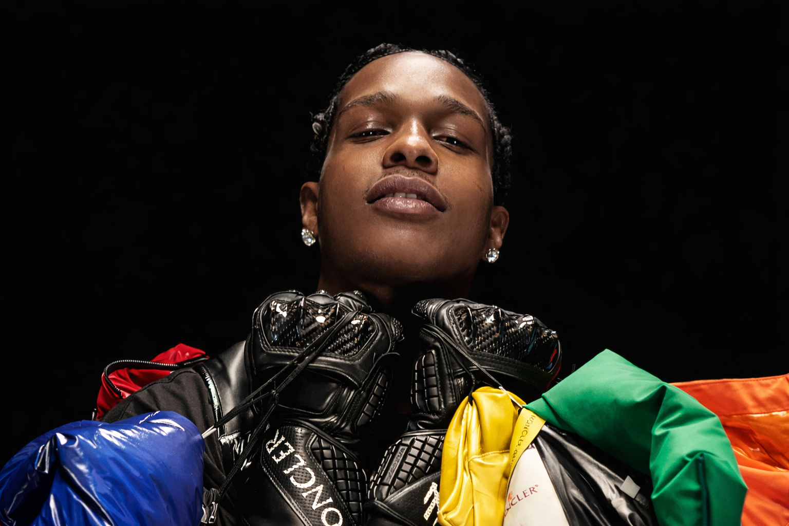 A$AP Rocky 穿著多色精品外套與黑色手套拍攝時尚特寫肖像,展現高端品牌聯名風格